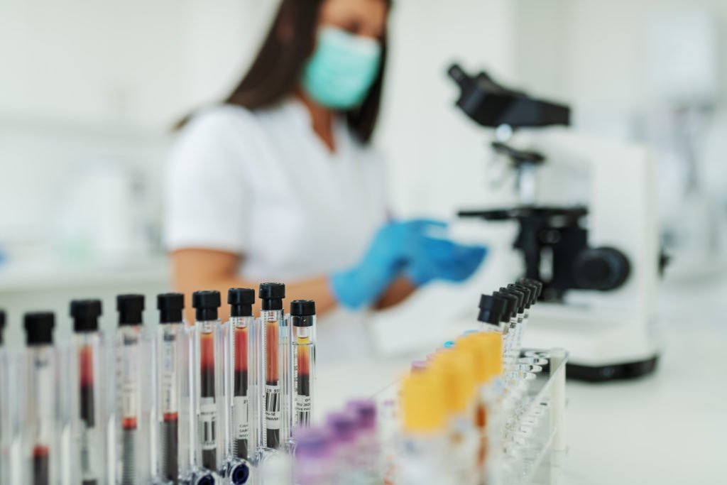 Pharmaceutical research scientist testing blood samples and creating clinical waste for removal