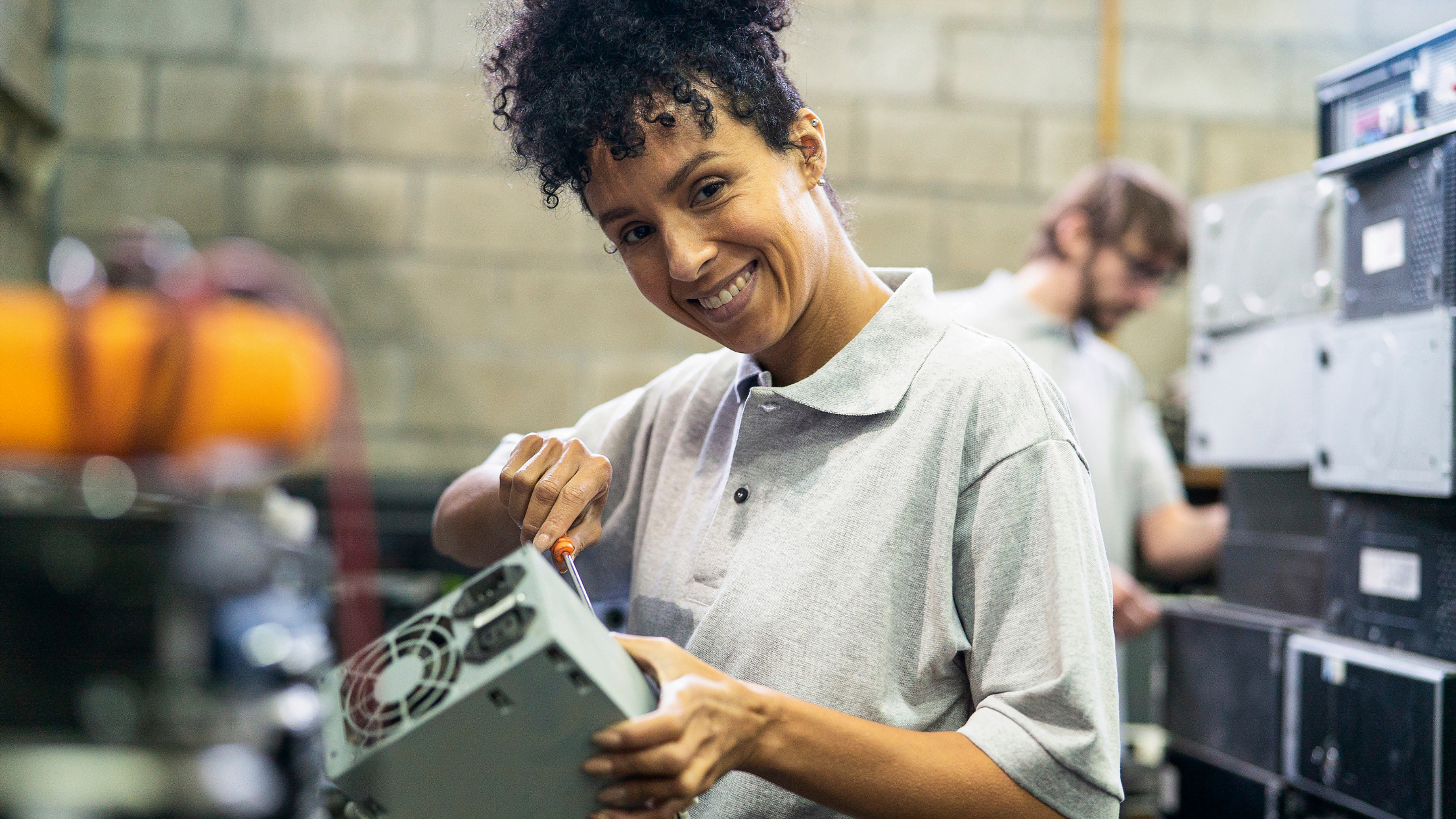 WEEE reuse - Female technician fixes computer parts