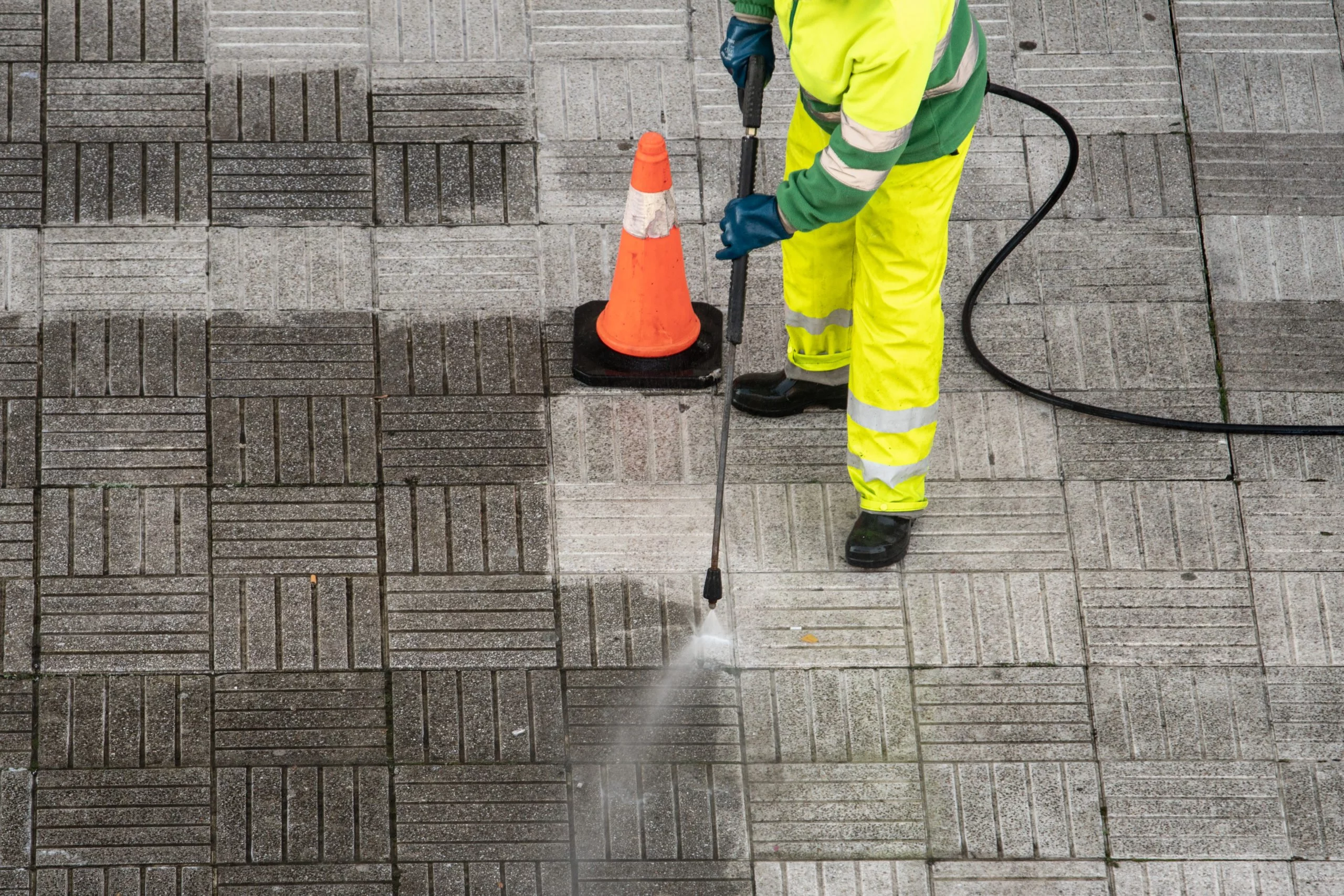 Worker cleaning the street sidewalk with high pressure water jet Community Cleaning - Worker cleaning the street sidewalk with high pressure water jet