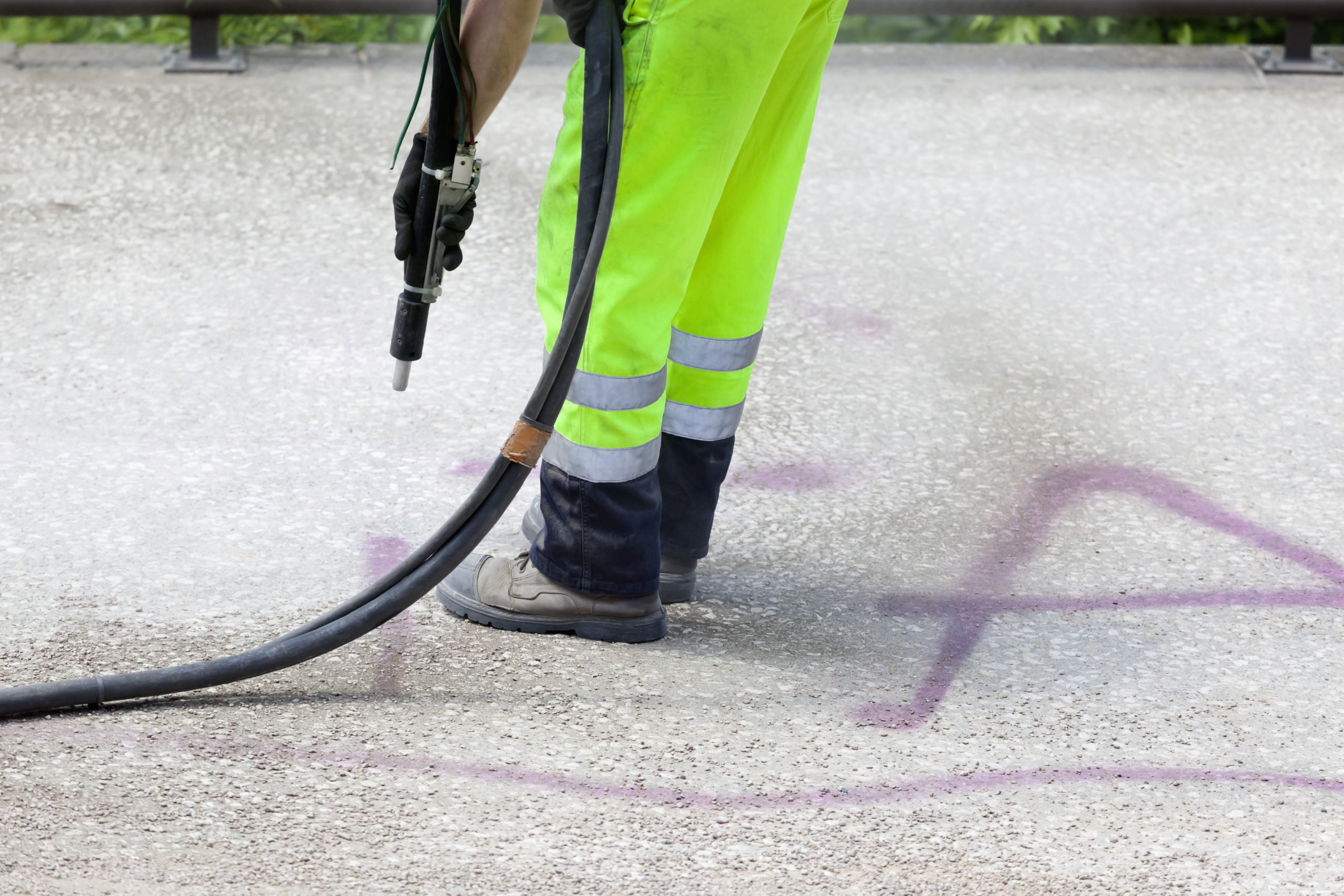 Community cleaning - man removing graffiti from public walkway