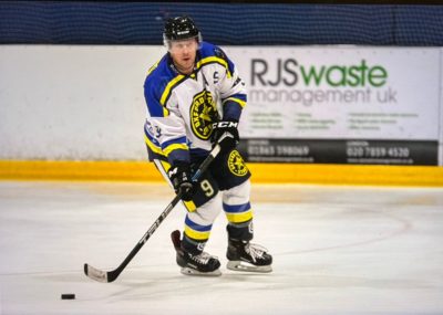 Oxford Rising Stars hockey player on the ice with RJS Waste sign behind